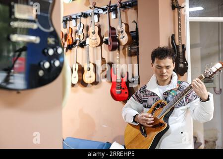 220303 -- GUIYANG, March 3, 2022 -- Guitarist Yang Zhi practices in Guiyang, southwest China s Guizhou Province, March 1, 2022. A band named Fish Mint consists of three massage therapists and a delivery man who were all born in the 1990s. Yet the delivery man is the only one who could see while the rest are with visual impairment. The members do their regular work during the day and gather around to play music in the band in the evening. The band is named after fish mint, as the members think they bear a resemblance to it. Fish mint, the leaf vegetable favored by the local people in southwest Stock Photo