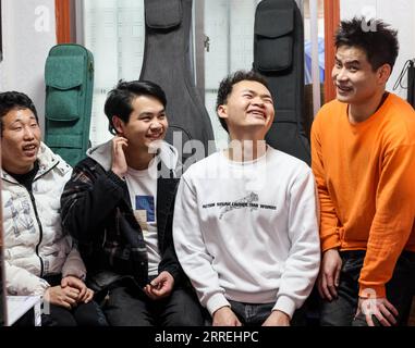 220303 -- GUIYANG, March 3, 2022 -- Lead singer Chen Kexing 1st L, guitarist Yang Zhi 2nd R, drummer Chen Changhai 1st R, and bassist Peng Wanhai 2nd L take a rest at a massage parlor in Guiyang, southwest China s Guizhou Province, March 1, 2022. A band named Fish Mint consists of three massage therapists and a delivery man who were all born in the 1990s. Yet the delivery man is the only one who could see while the rest are with visual impairment. The members do their regular work during the day and gather around to play music in the band in the evening. The band is named after fish mint, as t Stock Photo