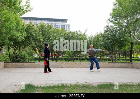 LUANNAN COUNTY, Hebei Province, China - May 4, 2020: two people practice Taiji sword in a park. Stock Photo