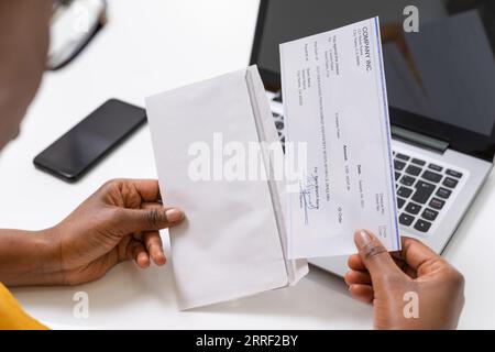 American African Holding Paycheck Or Payroll Check Stock Photo