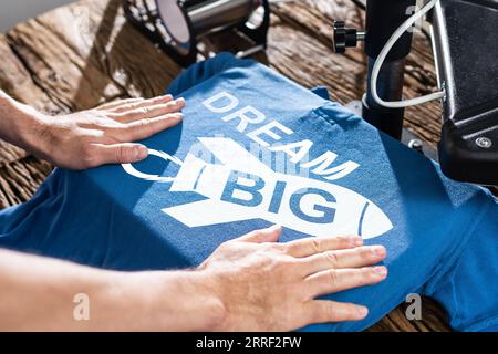 Man Printing On T Shirt In Workshop Stock Photo