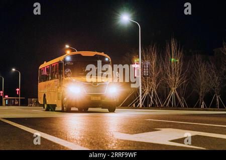 220408 -- CHANGCHUN, April 8, 2022 -- A school bus transporting supportive team members comes back from Changchun to Meihekou City, northeast China s Jilin Province, April 4, 2022. Some 5,000 supportive staff from Meihekou City who are aiding Changchun, one of the hardest-hit cities in China amid the latest virus resurgence, commute between the two cities every day in order to lessen boarding and lodging burdens on Changchun. The supportive team members, including medics, government officials and police officers, start off early morning and get back in late night, both by taking ferry buses. T Stock Photo
