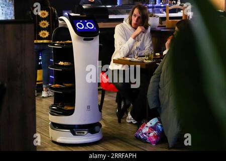 220410 -- SINT-NIKLAAS, April 10, 2022 -- A robot serves dishes at a restaurant in Sint-Niklaas, East Flanders, Belgium, April 9, 2022. Two service robots, designed and manufactured in China, became the stars of a restaurant in Sint-Niklaas in Belgium. They not only reduced the cost for the restaurant, but also won popularity among the customers.  BELGIUM-SINT-NIKLAAS-RESTAURANT-ROBOT ZhengxHuansong PUBLICATIONxNOTxINxCHN Stock Photo