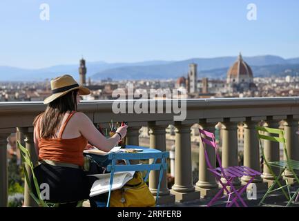 220415 -- FLORENCE, April 15, 2022 -- A woman paints at the Piazzale Michelangelo in Florence, Italy, on April 14, 2022.  ITALY-FLORENCE-DAILY LIFE JinxMamengni PUBLICATIONxNOTxINxCHN Stock Photo