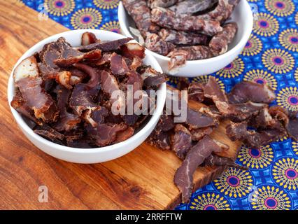 South African Traditional Biltong and dry wors on blue traditional printed cloth. Stock Photo