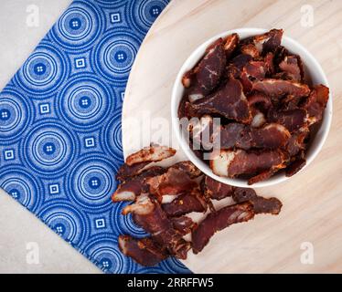South African Traditional Biltong and dry wors on blue traditional printed cloth. Stock Photo