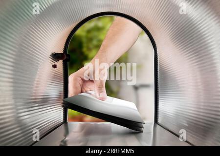 Close-up Of Person Hands Taking Letters View From Inside The Silver Mailbox Stock Photo