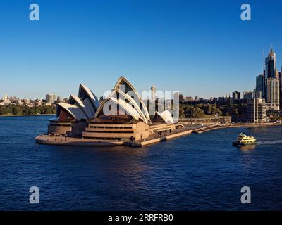 Sydney Australia / A Sydney commuter ferry passes the Sydney Opera House. A commuter ferry heads away from Circular Quay in Sydney Australia. Stock Photo