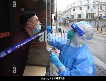 220426 -- SHANGHAI, April 26, 2022 -- A staff member takes a swab sample from a citizen discharged from a makeshift hospital for nucleic acid test in Huangpu District, east China s Shanghai, April 26, 2022. A mass nucleic acid test was carried out in Shanghai on Tuesday in closed-off management areas, restrictive control areas, and prevention areas. Shanghai has divided the whole city into areas belonging to three categories as part of targeted efforts to overcome a local COVID-19 resurgence.  CHINA-SHANGHAI-COVID-19-NUCLEIC ACID TESTING CN LixHe PUBLICATIONxNOTxINxCHN Stock Photo