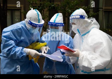 220427 -- SHANGHAI, April 27, 2022 -- Tian Ge L and He Yanping C check residents information with a community staff member in Beicai Town of east China s Shanghai, April 26, 2022. Tian Ge and He Yanping, both general practitioners, conduct a door-to-door nucleic acid test for residents without negative results in mass testing or antigen testing in Beicai.  CHINA-SHANGHAI-BEICAI-NUCLEIC ACID TEST CN JinxLiwang PUBLICATIONxNOTxINxCHN Stock Photo