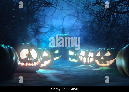 Halloween Backdrop. Halloween Pumpkins In Spooky Forest At Night. Gloomy forest sunset with haunted evil glowing eyes of Jack O' Lanterns on scary hal Stock Photo