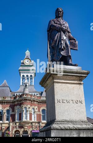 St Peters Hill Grantham Lincolnshire – Statue of Sir Isaac Newton who went to school in the town, against a summer sky with the Town Guildhall in the background Stock Photo