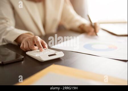 Close-up hand image of a professional businesswoman or female accountant using a calculator, working on business financial reports, and analyzing fina Stock Photo