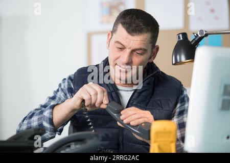 elctrician repair a phone in his workshop Stock Photo