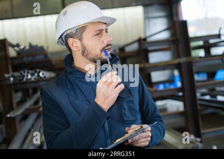 engineer taking notes at control room in factory Stock Photo