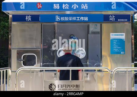 220508 -- SHANGHAI, May 8, 2022 -- A staff member takes a swab sample ...