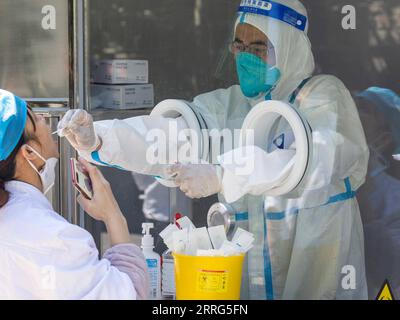 220508 -- SHANGHAI, May 8, 2022 -- A staff member takes a swab sample ...