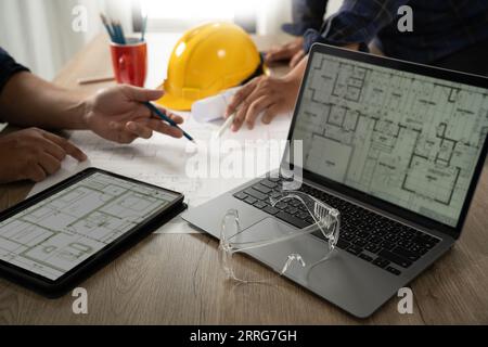 Engineer A construction technology worker checks an engineer using a computer on a construction site. Engineer teams in architecture, development, and Stock Photo
