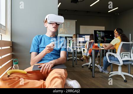 Student using VR glasses while sitting at lesson in the classroom Stock Photo