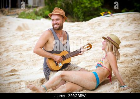 Young couple with ukulele on the beach. Stock Photo