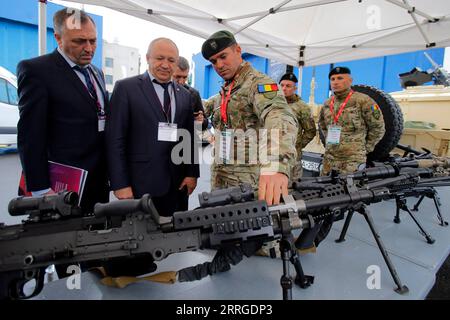 220518 -- BUCHAREST, May 18, 2022 -- Visitors look at machine guns at the Black Sea Defense and Aerospace Exhibition in Bucharest, capital of Romania, on May 18, 2022. Photo by /Xinhua ROMANIA-BUCHAREST-BSDA EXHIBITION CristianxCristel PUBLICATIONxNOTxINxCHN Stock Photo