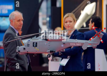 220518 -- BUCHAREST, May 18, 2022 -- Visitors look at a military helicopter s model at the Black Sea Defense and Aerospace Exhibition in Bucharest, capital of Romania, on May 18, 2022. Photo by /Xinhua ROMANIA-BUCHAREST-BSDA EXHIBITION CristianxCristel PUBLICATIONxNOTxINxCHN Stock Photo