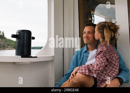daughter kissing her father on the cheek whilst travelling Stock Photo