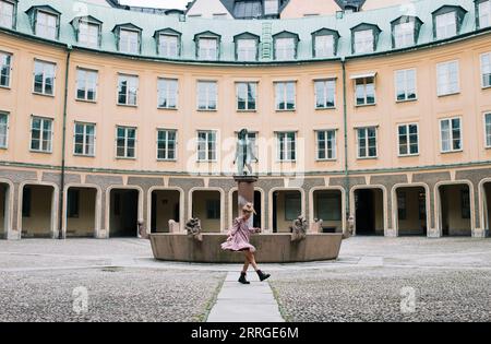 girl dancing in front a beautiful building in Gamla Stan, Stockholm Stock Photo