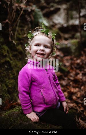 Child posing outdoors wearing a natural ivy crown Stock Photo
