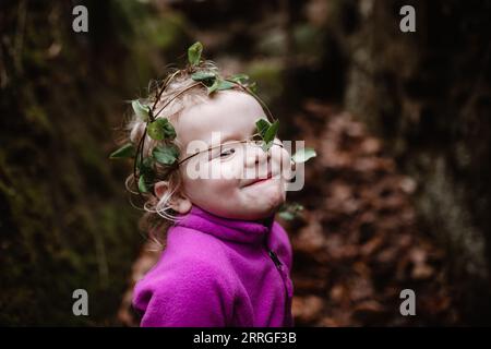 Smiling child outdoors wearing natural ivy crown Stock Photo