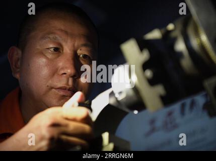 220527 -- XINMI, May 27, 2022 -- Cheng Yucai operates a Guilloche machine at his workshop in Xinmi City, central China s Henan Province, on May 24, 2022. Guilloche is a decorative technique in which a precise, intricate and repetitive pattern is mechanically engraved into a material via engine turning. The technique uses a machine controlled by the delicacy of the hand of craftsman. As an important process in making superior watch and jewelry, the art is now mastered by rarely few people. Cheng Yucai, born in 1978, got to know Guilloche in 2013 when he saw a cigarette case decorated with the t Stock Photo