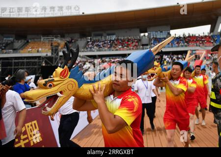 220602 -- CHANGSHA, June 2, 2022 -- Dragon boat crew members shouldering dragon-head-shaped carvings participate in a ceremony before a traditional Chinese dragon boat race in Miluo City, central China s Hunan Province, June 2, 2022. A dragon boat race including 11 competition teams was held here on the eve of this year s Dragon Boat Festival which will fall on Friday.  CHINA-HUNAN-DRAGON BOAT FESTIVAL-BOAT RACE CN ChenxZhenhai PUBLICATIONxNOTxINxCHN Stock Photo