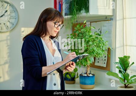 Portrait of specialist woman with clipboard in office Stock Photo