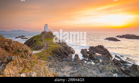 Twr Mawr Lighthouse, Ynys Llanddwyn, Anglesey, North Wales, UK with dramatic winter sun setting over the Menai Strait sea. Stock Photo