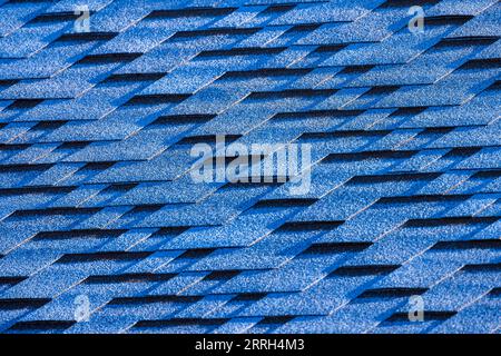 Blue roof tiling made of flexible shingles, background photo texture of a modern house roof Stock Photo