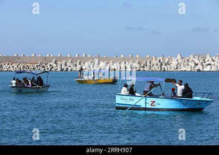 220620 -- ALEXANDRIA, June 20, 2022 -- People row boats on the sea with concrete barriers used against sea-level rises in the background in Alexandria, Egypt, June 19, 2022. The Egyptian Ministry of Water Resources and Irrigation has launched a climate adaptation project on the North Coast and the Nile Delta to counter sea-level rises, the impact of weather hazards on low-lying coastal areas, and seawater intrusion.  EGYPT-ALEXANDRIA-CLIMATE CHANGE-RISING SEA LEVEL-COASTAL CONCRETE BARRIER AhmedxGomaa PUBLICATIONxNOTxINxCHN Stock Photo