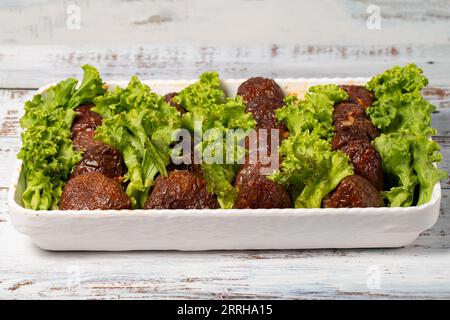 Stuffed zucchini. Stuffed zucchini stuffed with rice on a white wood background Stock Photo