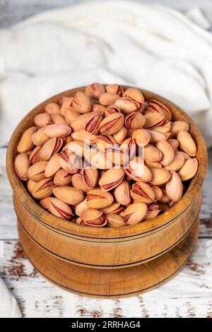 Pistachios in wooden bowl. Pistachios on white wood background Stock Photo