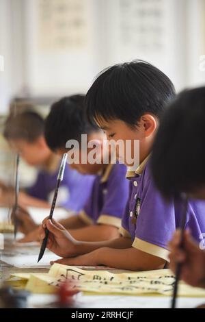 220625 -- BAOTOU, June 25, 2022 -- Students learn calligraphy during an after-class activity in a primary school in Baotou, north China s Inner Mongolia Autonomous Region, June 24, 2022. Schools in Baotou organized varied after-class activities to enrich the students school time.  CHINA-INNER MONGOLIA-BAOTOU-SCHOOL-AFTER-CLASS ACTIVITIES CN PengxYuan PUBLICATIONxNOTxINxCHN Stock Photo