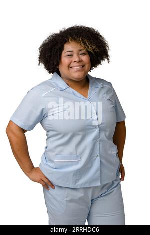 Waist up vertical portrait of young venezuelan afro latina woman in blue uniform, afro hair, standing smiling and looking at camera happy. White backg Stock Photo