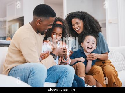 Thumb war, happy family and living room sofa with love, support and fun with parents and kids. Home, mother and father with children and funny joke on Stock Photo