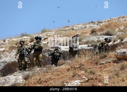 220708 -- NABLUS, July 8, 2022 -- Israeli soldiers fire tear gas canister at Palestinian protesters during clashes with Israeli soldiers following a protest against the expansion of Jewish settlements in the West Bank village of Beit Dajan, east of Nablus, July 8, 2022. Photo by Ayman Nobani/Xinhua MIDEAST-NABLUS-CLASHES LiuxWeijian PUBLICATIONxNOTxINxCHN Stock Photo