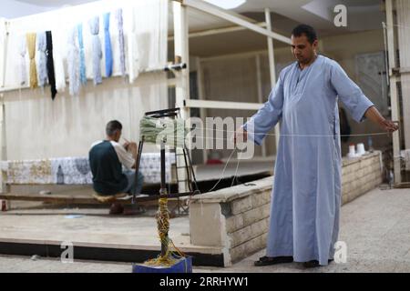 220710 -- GIZA, July 10, 2022 -- A man arranges thread at a weaving workshop at Saqqara village in Giza, Egypt, July 2, 2022. Overlooking Saqqara necropolis, some 20 kilometers from the Giza pyramid complex, Saqqara village lies as a tourist attraction with its unique handmade rugs and carpets that represent a characteristic handicraft of the locals for decades. TO GO WITH Feature: Egyptian carpet schools improve locals lives in Saqqara village  EGYPT-GIZA-HANDMADE CARPET SCHOOL AhmedxGomaa PUBLICATIONxNOTxINxCHN Stock Photo