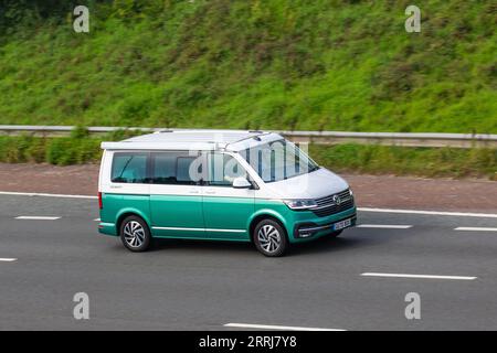 2020 VW Volkswagen California Ocean Tdi S-A Tdi 150 DSG Bluemotion Auto Start/Stop 2 Berth Green White Motorhome Camper Van Diesel 1968 cc travelling at speed on the M6 motorway in Greater Manchester, UK Stock Photo