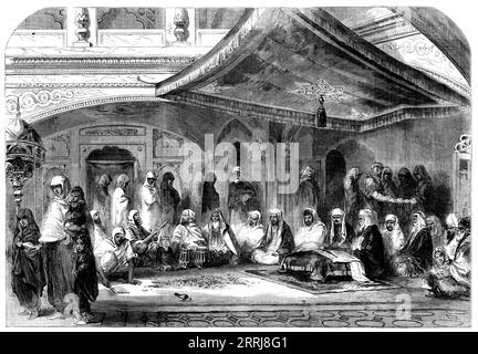 Interior of a Sikh Temple at Umritzir [in India] - reading the Grunt'h - from a drawing by W. Carpenter, Jun., 1858. 'The Gooroos are the spiritual guides of the Sikhs. Arjoon, fourth Gooroo, arranged the various writings of his predecessors. Namuk and Unggud added to them the best known or the most suitable compositions of some other religious reformers, and, completing the whole with a prayer and some exhortations of his own, he declared the compilation to be pre-eminently the &quot;Grunt'h,&quot; or book...The Gooroo is sitting before the Grunt'h, which lies open on a stool before him, cove Stock Photo