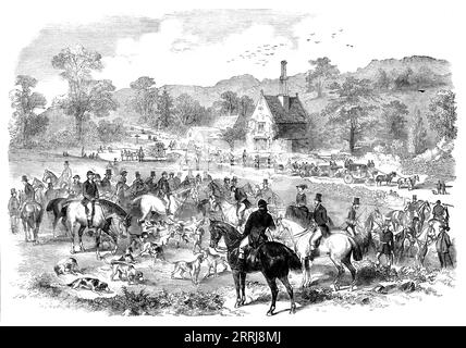 First Meet of the Season of the Cotswold Hounds, 1858. Fox hunting in rural England. Engraving from a sketch by Mr. G. Goddard. 'These hounds, under the mastership of Clego Colmore, Esq., commenced their season on Monday, November 1st, at Dowdeswell Wood, situated about three miles out of Cheltenham, on the London road. The meet was numerously attended by the elite of Cheltenham...the hounds were thrown into cover, and, finding [the scent] immediately...they rattled him up through the wood, and &quot;Charley,&quot; after two or three futile attempts to break cover, stole away in the direction Stock Photo