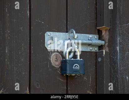 Brenton Padbolt Fitted to a Wooden Door and Locked with a Squire Stainless Steel Weatherproof Padlock Stock Photo