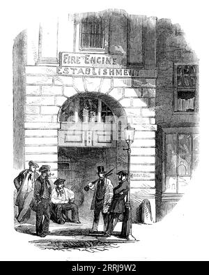 Chandos-street Fire-Engine Station, [London], 1858. '...one of those places scattered throughout the metropolis where, day and night, a portion of the fire brigade is in readiness to start at a moment's notice to any part of London. At these houses the engines are always in readiness, the horses with their equipments are prepared for instant action, and the men may be said to sleep in harness; so that should an alarm be given in the dead of night the engine is in a few minutes on its way to the place of the fire, rattling over the pavement with that peculiar sound which distinguishes the progr Stock Photo