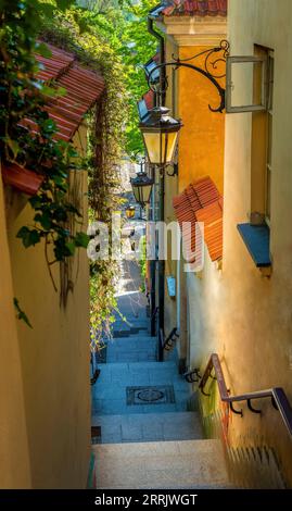 Narrow street with stairs and lamps in the Old town of Warsaw, Poland Stock Photo