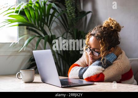 Tired woman at home asleep in front of a computer. Overwork laptop use concept. Female people sleeping on the table while use notebook. Unhappy mental bad condition mature lady and online activity Stock Photo